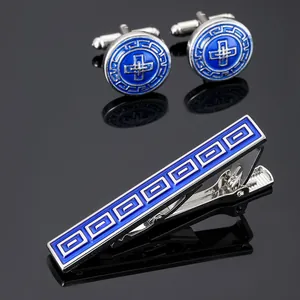 Close-up of silver cufflinks and tie clip set with blue geometric Greek fret pattern