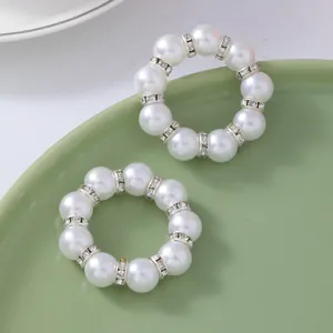 U-shaped champagne gold napkin rings with white pearls and sparkling diamond accents