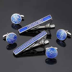 Detailed macro view of silver-tone cufflinks and tie clips with blue enamel pattern