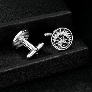 Silver cufflinks with engraved totem pattern on black jewelry box display