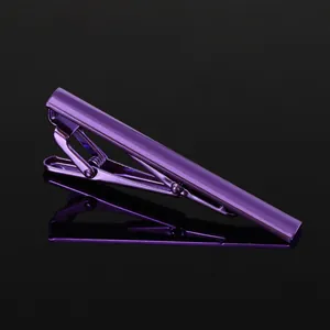Macro shot of minimalist purple metallic tie clip with polished finish on black background