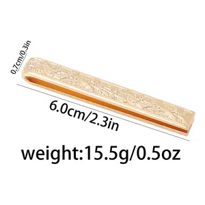 Macro-opname van een 6 cm gouden stropdasclip met elegant gegraveerd bloemenpatroon