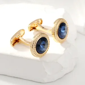 Makro-Detail goldener Manschettenknöpfe mit tiefblauen Edelsteinen und Kordelrand-Design