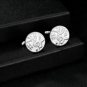 Detailed close-up of silver musical note cufflinks on a black leather texture display