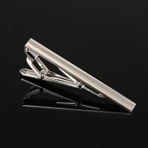 Macro shot of polished silver tie clip with blue stripe on high-gloss black background