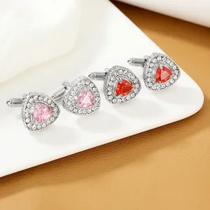 Nahaufnahme von rosa und roten Dreiecks-Manschettenknöpfen mit Zirkonia-Besatz