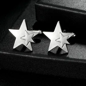 Macro shot of silver polished double star cufflinks on black leather texture