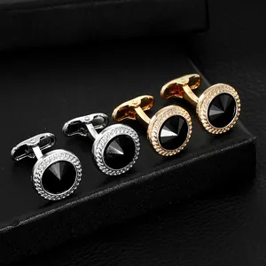 Detailansicht der runden Manschettenknöpfe in Gold und Silber mit schwarzer Einlage in Box