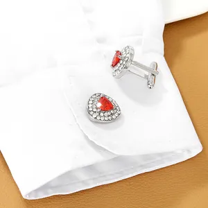 Dettaglio di gemelli da uomo in argento con pietra rossa e bordo di cristalli bianchi
