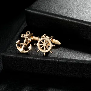 Macro detail of nautical gold anchor and helm cufflinks on black jewelry box