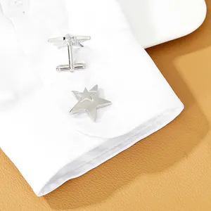 Detail of silver star-shaped cufflinks on a white shirt cuff with a leather background