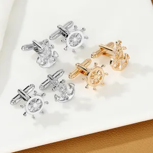 Detail shot of silver and gold nautical steering wheel and anchor cufflinks for men