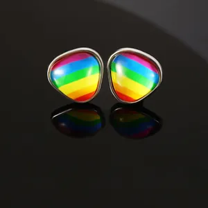 Makroaufnahme von dreieckigen Regenbogen-Ohrringen mit Silberrahmen auf schwarzem Spiegel