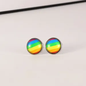Detailaufnahme runder silberner Manschettenknöpfe mit bunten Regenbogenstreifen unter Glas