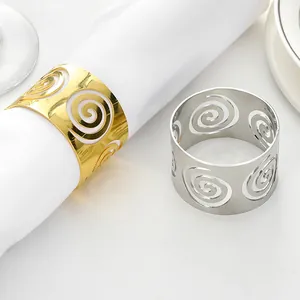 Detail of gold and silver spiral hollow napkin rings on a white napkin at a set table
