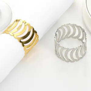 Close-up of hollow wave pattern napkin rings in gold and silver finish with metal texture