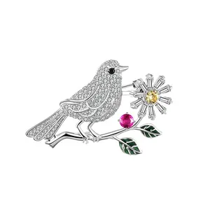 Detailed view of crystal bird brooch with green enamel leaves and daisy accents