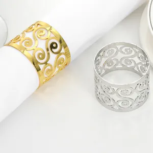 Detailed view of hollow scroll pattern napkin rings in gold and silver finishes