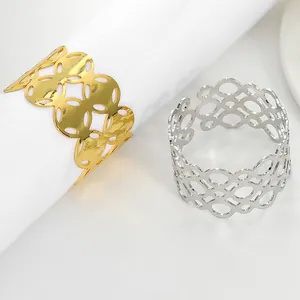 Detail view of interlocking hollow geometric metal napkin rings in gold and silver finish