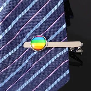 Détail macro d'un pince à cravate arc-en-ciel argenté sur une cravate en soie bleu foncé
