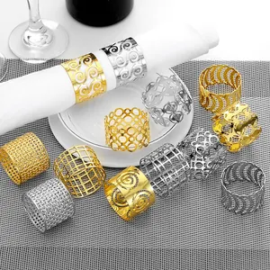 Detailed view of hollow patterned gold and silver metal napkin rings on elegant table setting