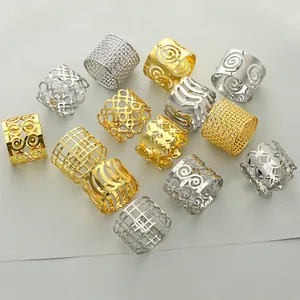 Detailed view of hollowed-out metal napkin rings in gold and silver plated finishes
