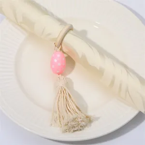 Detalle del servilletero de madera con huevo de lunares rosa y borla de algodón