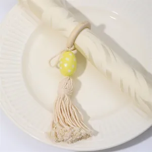 Detalle de servilletero de madera con huevo de Pascua de lunares amarillos y borla de algodón