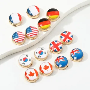 Detail shot of round gold-tone cufflinks featuring vibrant national flags on white marble