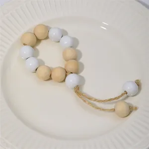 Servilleteros de cuentas de madera natural con borlas de yute en plato de cerámica