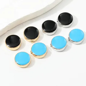 Macro shot of circular enamel cufflinks in black and blue with gold and silver metal bases