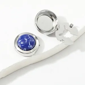 Detailed view of silver cufflink showing blue marble inlay and flip-top mechanism