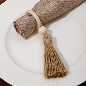 Detalle de servilletero artesanal de cuentas de madera con borla de yute