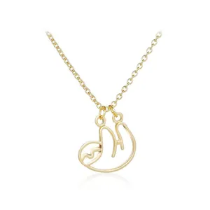 Detailed close-up of a golden minimalist sloth pendant necklace with polished finish