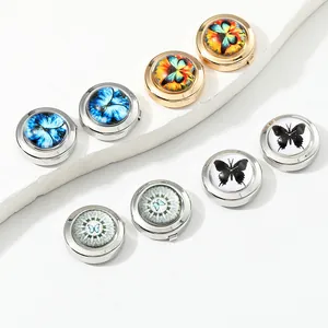 Macro view of round metal cufflinks with colorful butterfly patterns on white pedestals