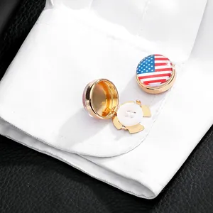Detail of gold metal button cover with American flag design on a white shirt cuff