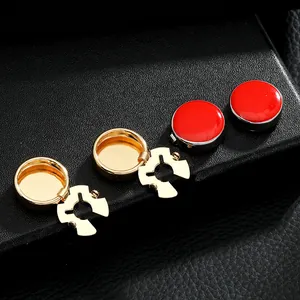 Detailed macro view of four metallic button covers in gold and red enamel on a black stand