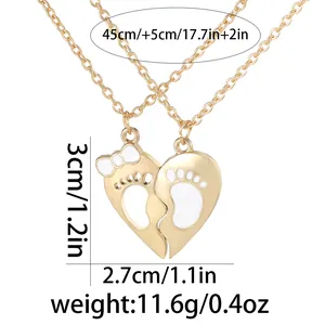 Golden heart-shaped couple necklaces with footprints and bow detailing on white background