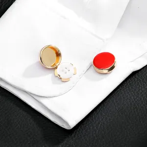 Detail view of red enamel and gold metal button covers for formal shirt cuffs