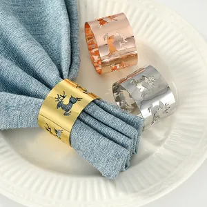Primer plano de servilleteros de metal calado con diseño de reno en oro, plata y rosa