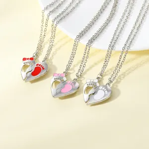 Close-up of heart-shaped footprint pendants in red, pink and white with silver chains