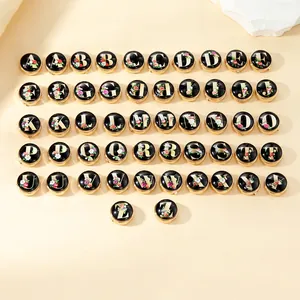 Macro shot of 26 round letter cufflinks with colorful floral designs on a beige background