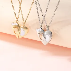 Close-up of heart puzzle necklace featuring gold and silver finish with baby footprints
