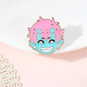 Gros plan d'un badge émaillé rose et bleu représentant un garçon démon aux bords dorés