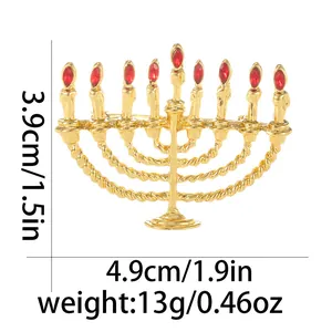 Detailansicht der goldenen Menorah-Brosche mit roten Kristallen und Größenangaben 3,9x4,9cm