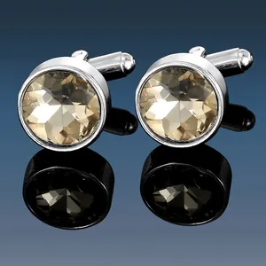Macro shot of silver metal cufflinks with faceted champagne satellite stones and reflection