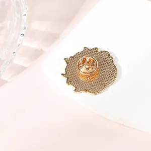 Badge en métal doré vue arrière avec fermoir papillon sécurisé et bordure dentelée