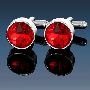 Macro detail of men's silver cufflinks featuring multifaceted round red stones and reflections