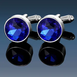 Macro shot of silver cufflinks featuring round deep blue faceted crystals and polished finish