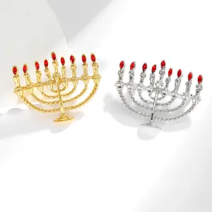 Detailansicht der goldenen und silbernen Menora-Broschen mit roten Edelsteinen und Kordeldesign